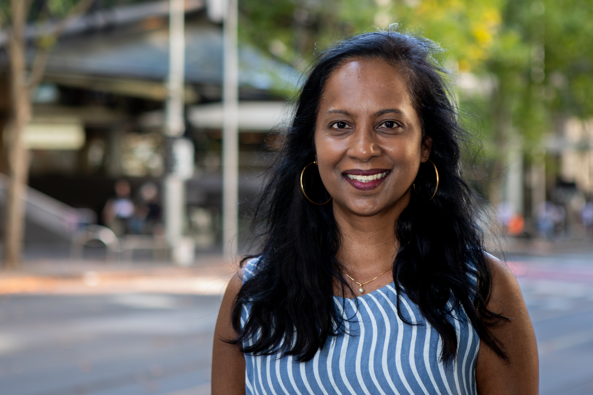 Picture of woman with blue and white stripe top smiling 