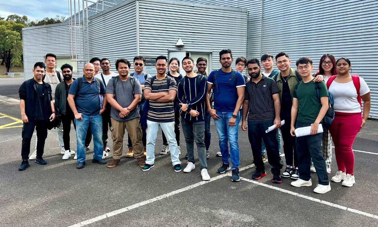 Group of students posing for photo outside of RMIT Bundoora campus.