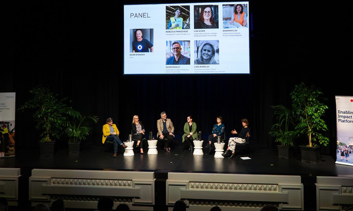 Panel members seated on stage, engaged in conversation