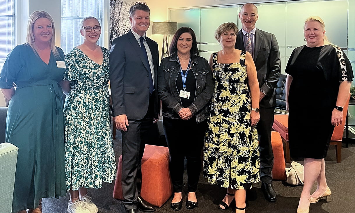 5 women and 2 men stand next to each other.