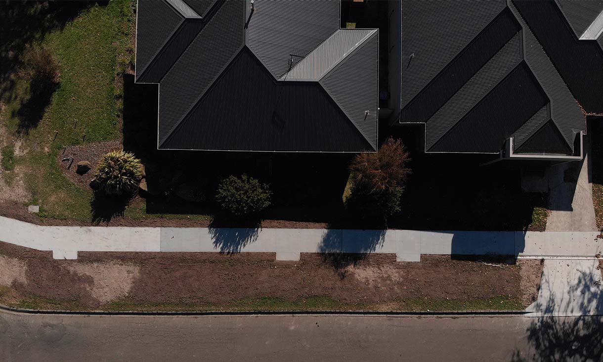 Aerial view of the finished footpath in Gisborne. The three panels attached to the footpath indicate different types of concrete used in the footpath, as part of the trial. The right panel indicates the section using coffee biochar in the concrete; the middle section uses wood chip biochar; the left section is the control, which uses standard concrete ingredients only. Credit: Chris Matthews, Macedon Ranges Shire Council