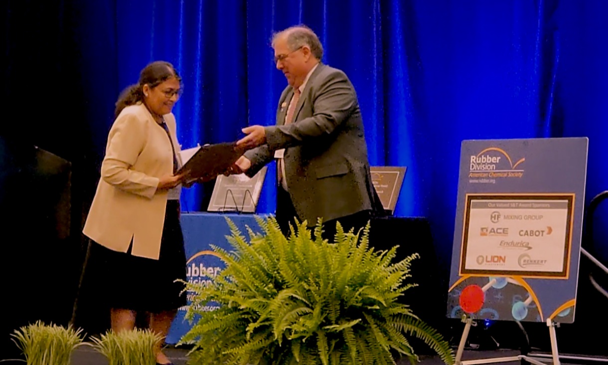 Professor Namita Roy Choudhury collecting her award on stage.