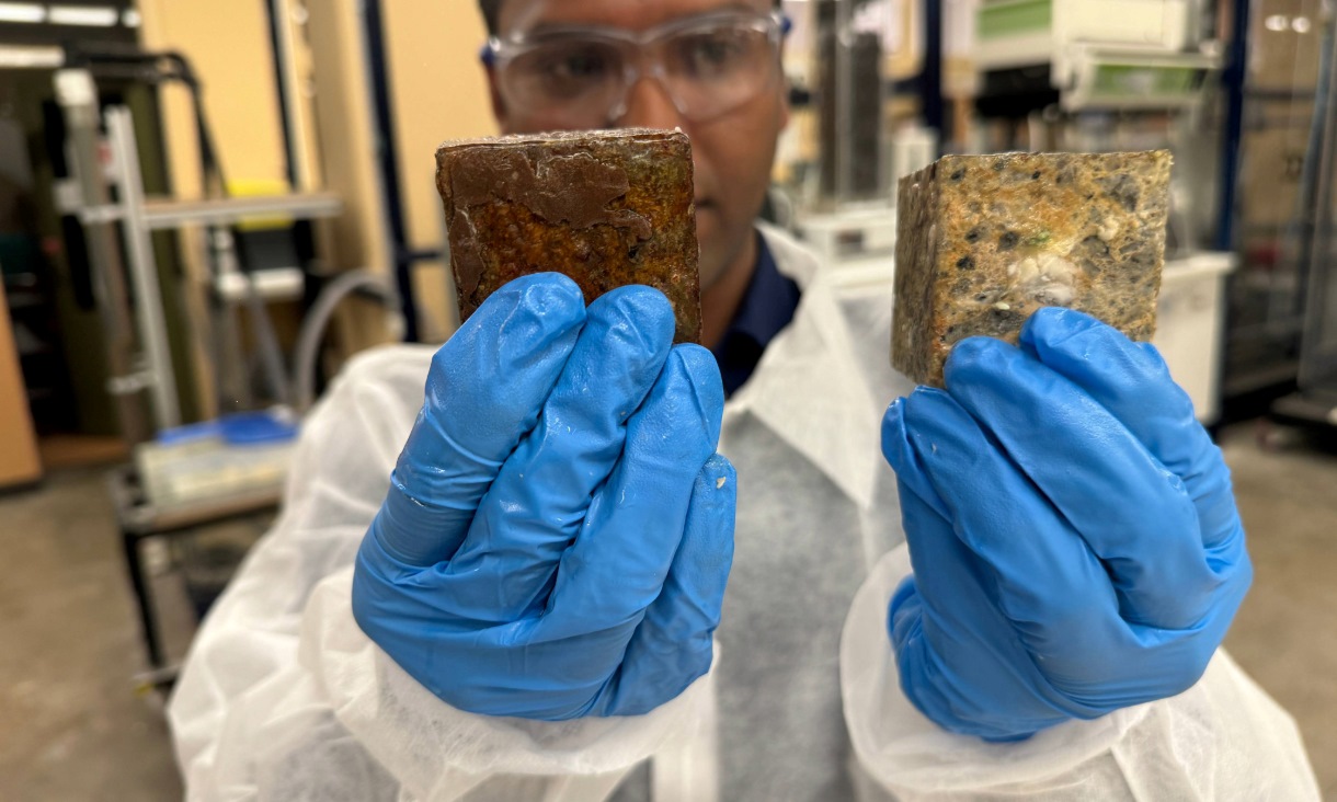 Dr Biplob Pramanik shows the difference between a concrete block coated with his team’s anti-fatberg invention compared to a block without any coating after undergoing an experiment that mimicked a sewer environment under extreme conditions to speed up the fatberg formation process. The white coloured blobs on the uncoated block are a mixture of fat, oil and grease (FOG). Credit: Will Wright, RMIT University