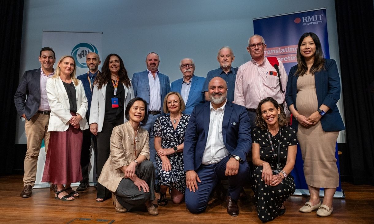 Group photo of symposium contributors on stage.
