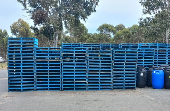 Study participant Enele photographed towering pallets and lower drums as a visual metaphor for perceived ethnic–based pay inequality.