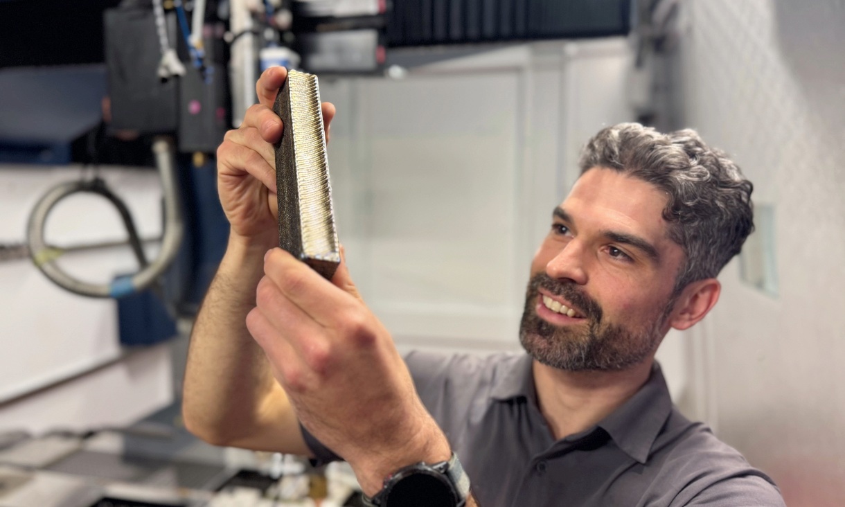 PhD candidate and study lead author Ryan Brooke inspects a sample of the new titanium. 