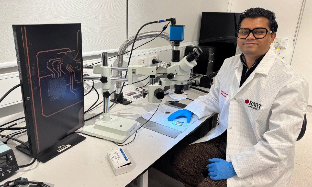 Dr Peter Francis Mathew Elango seated in a lab equipped with microscopes and screens, focused on advancing wound care technology.