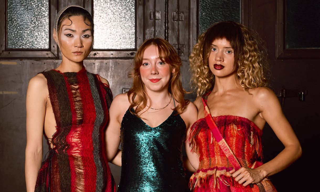 Graduate posing with two models