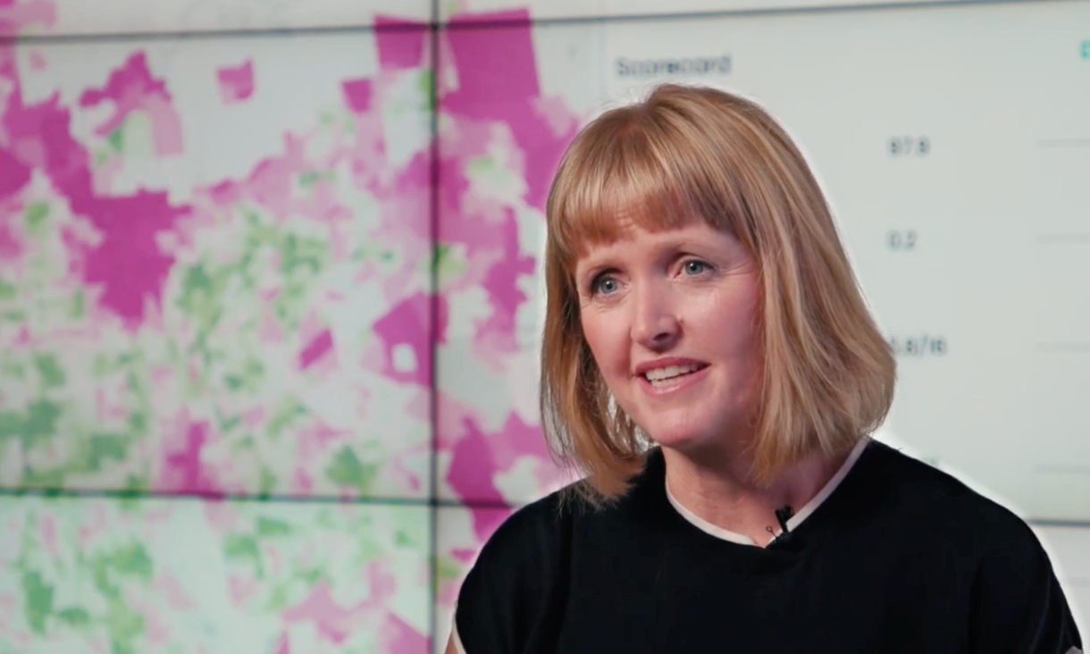 Professor Melanie Davern in front of Australian Urban Observatory visualisations.