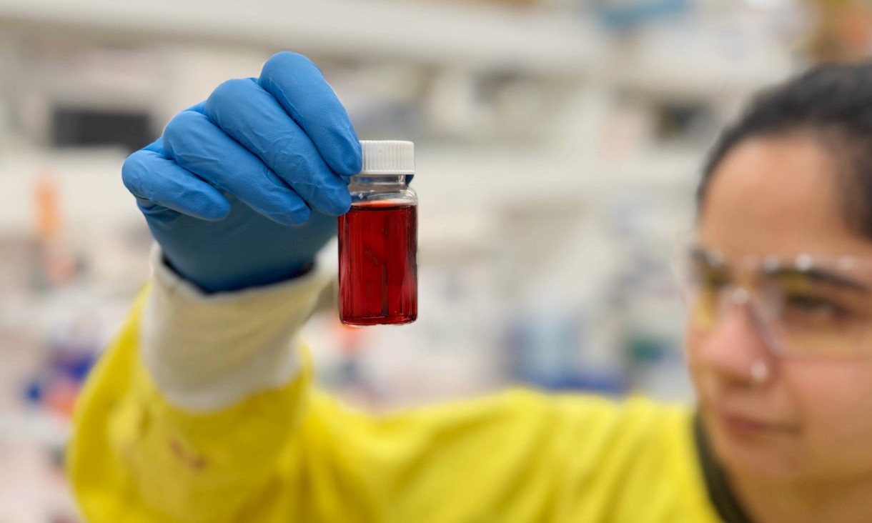 Sanskruti Lakhotia from RMIT's Sir Ian Potter NanoBioSensing Facility holds a bottle of the nanoparticle formula being used to develop Nexsen's kidney diagnostic tests.