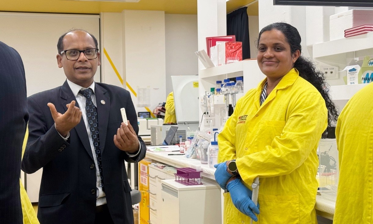Professor Vipul Bansal holding an early prototype of the kidney test in the RMIT labs with research team leader Dr Pabudi Weerathunge.