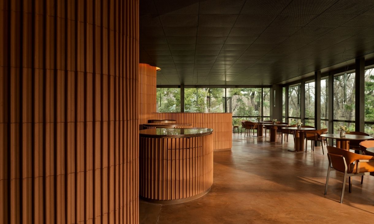 A warm building interior, with large windows and wood features.