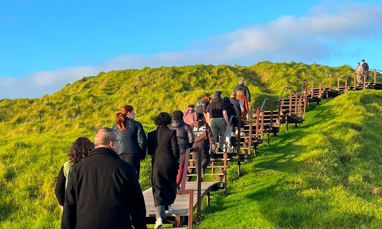 Students walking through lush green landscape.