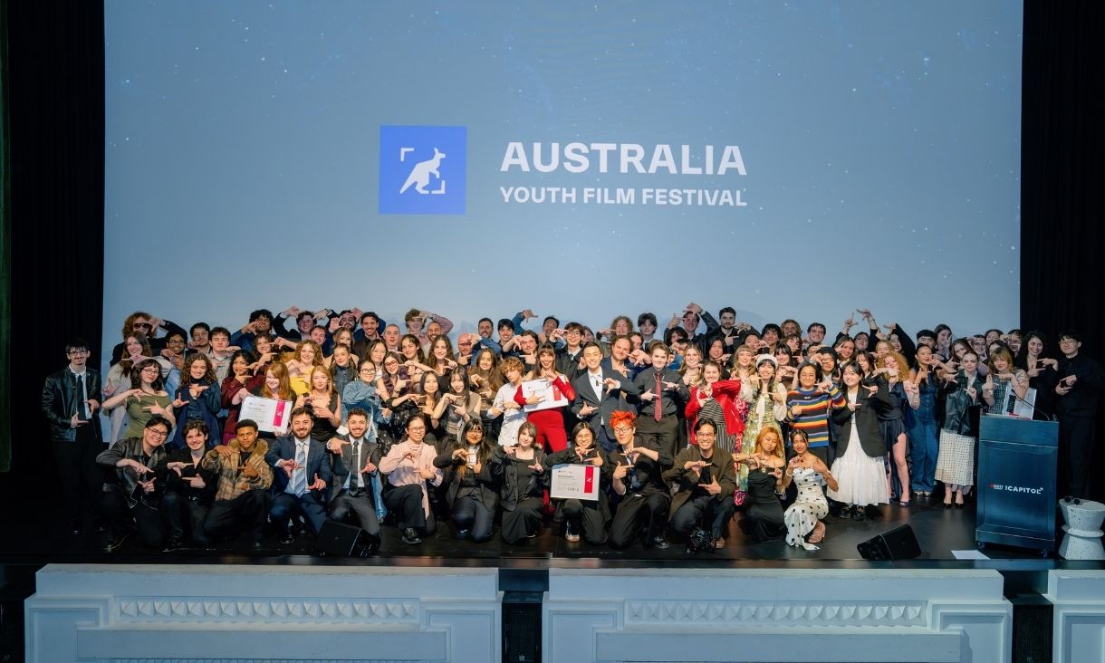 a large group of students stand together on the stage at the award ceremony in a fun group shot