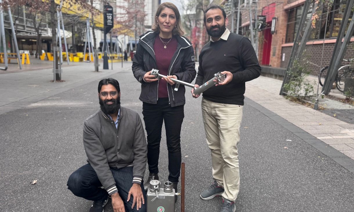 Three researchers holding water-treatment technology components.