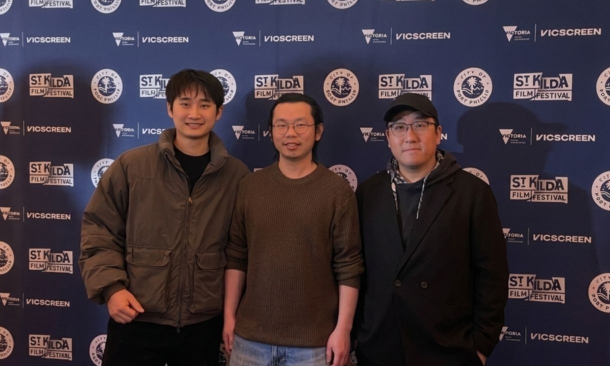 Tian, Ji and Gao stand in front of a St Kilda Film Festival banner 