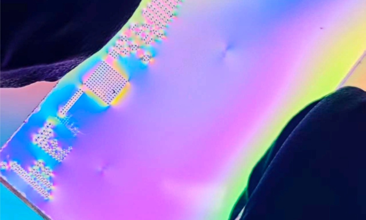 Close up of a small chip device showing iridescent colour patterns, demonstrating optical structures that manipulate light.