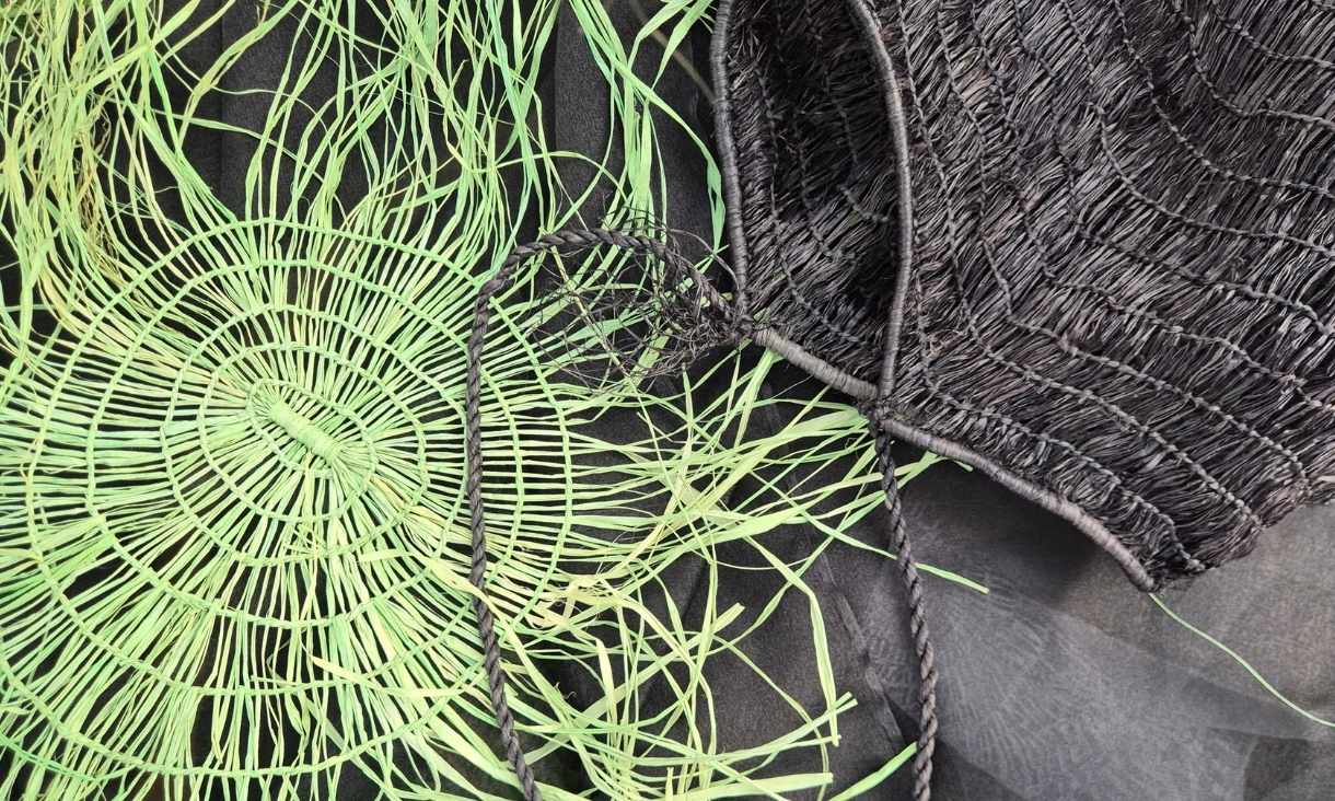 Tarsha's designs up close depict a lime green woven piece sitting over a black textured fabric 