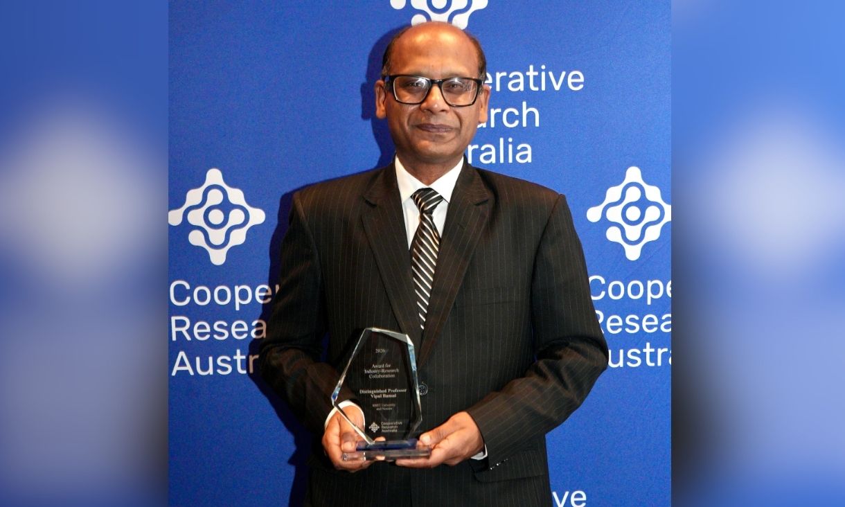 Vipaul Bansal stands with his glass award. 