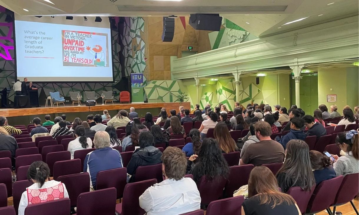 A busy seminar showing a screen.