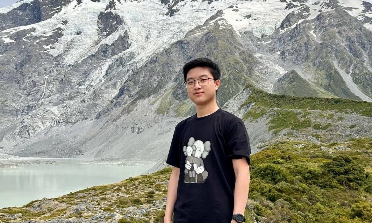 Michael stands with a background of alps 