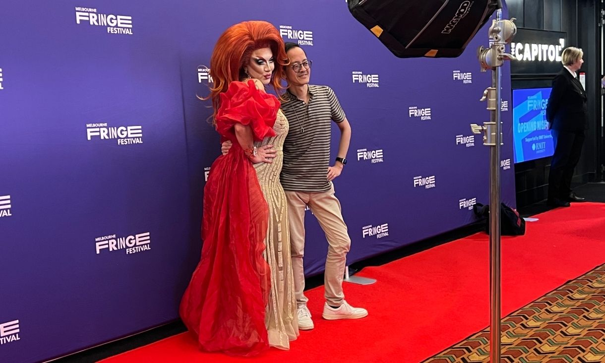 A drag queen poses with a guest in the capitol foyer