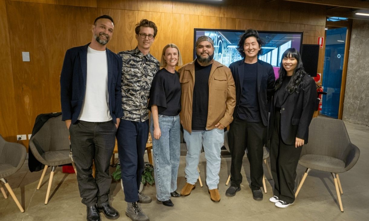 Six people stand together smiling for a photo