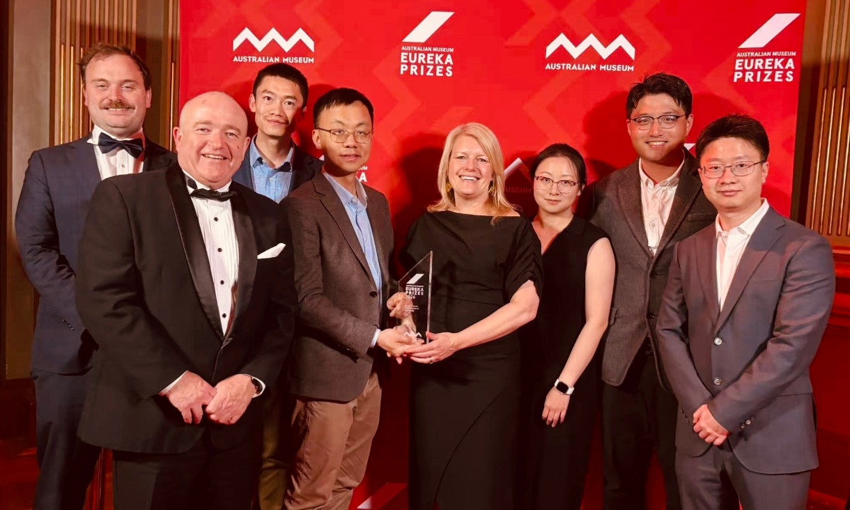 People standing in front of a banner for the Eureka Prizes.