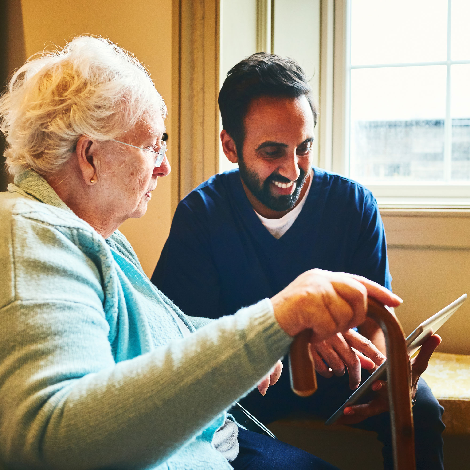 Image of a person in a healthcare facility talking to a staff member