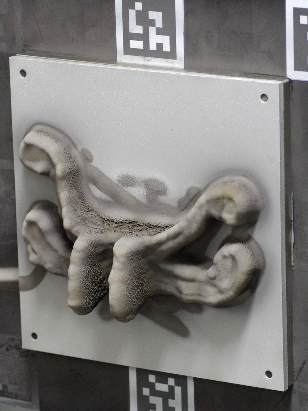 (b) finished engine bracket. Loose Ti is visible on the as-sprayed part’s surface, particularly on the overhanging sections.