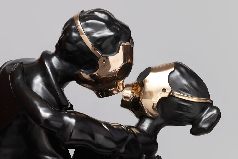 A sculpture of two adults embracing face to face, both wearing full face gas masks