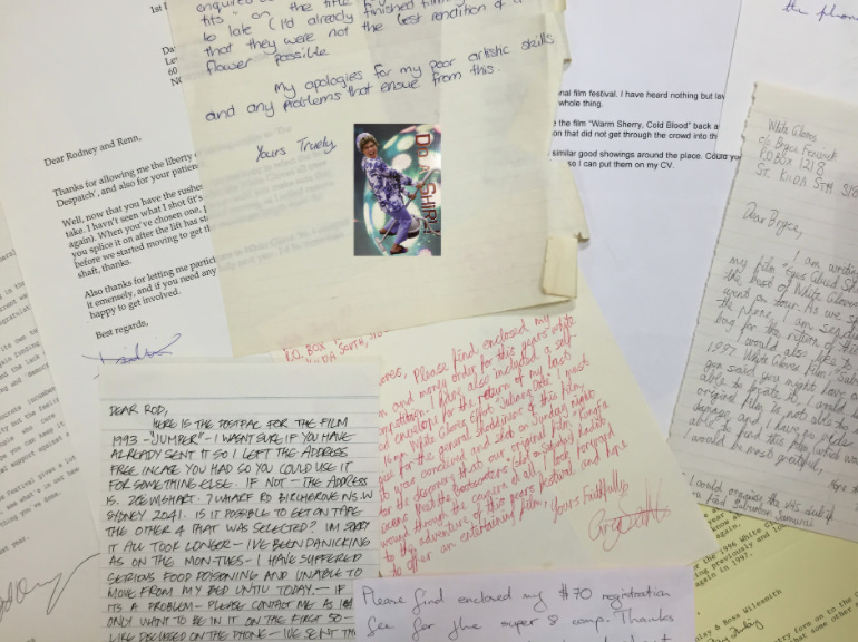 A photo of assorted handwritten and typed letters scattered over a flat surface