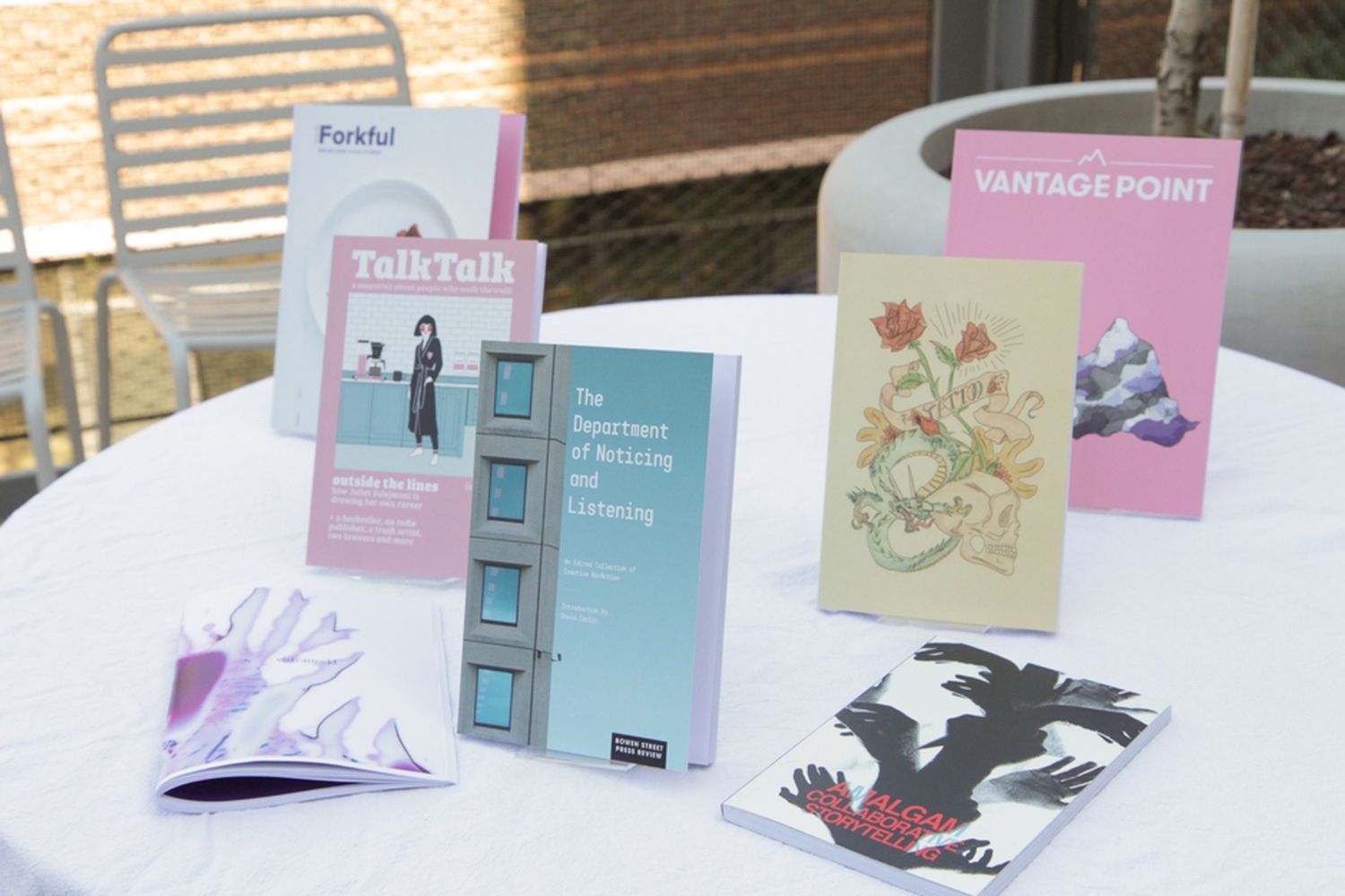 A white table with 7 magazines published by Bowen Street Press