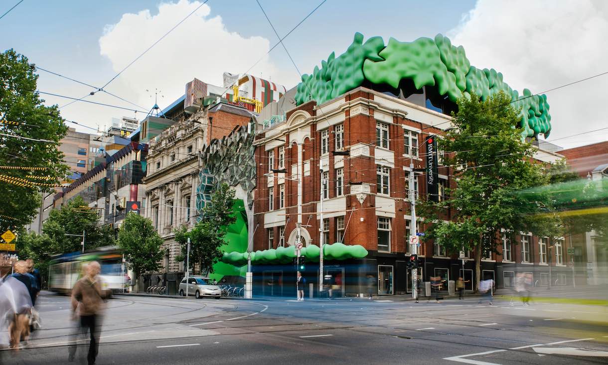 action photo of RMIT city campus 'green brain' building with road and foot traffic