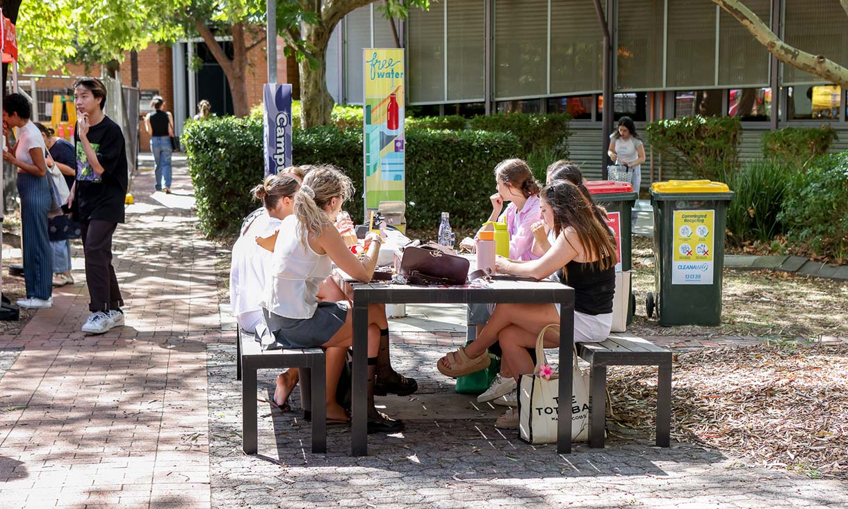Students sitting outside around a table