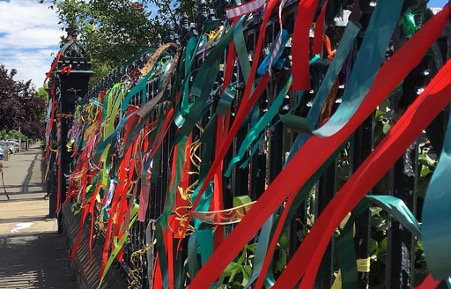 Fence filled with ribbons tied to it