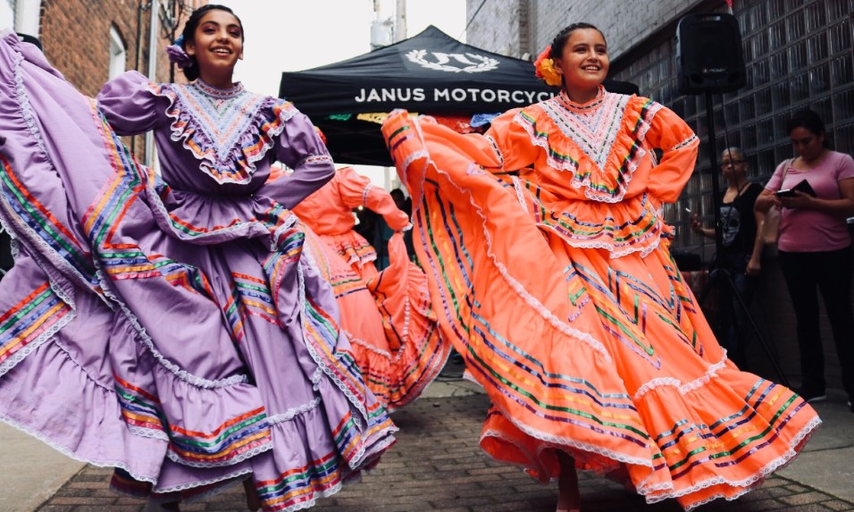 Two women in traditional Spanish dresses dancing
