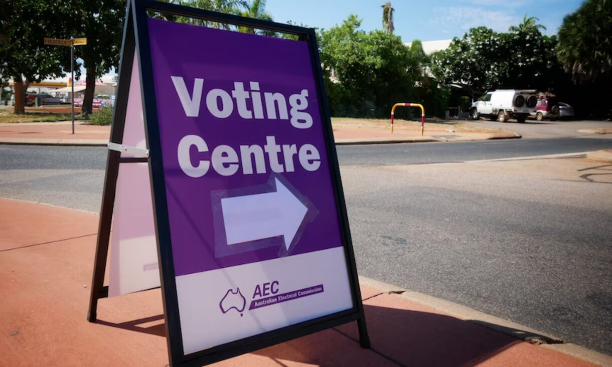 White and purple Australian Electoral Commission voting centre sign on the pavement