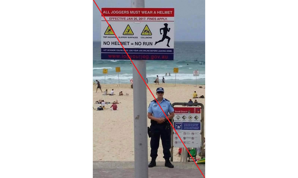photograph of sign warning joggers to wear helmets with police officer standing nearby