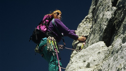 woman climbing rock cliff 