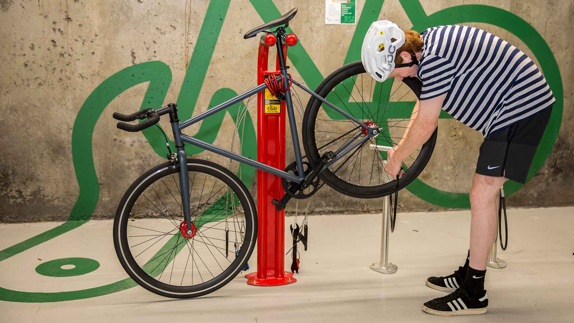 A person using the bike pump to put air in their tyres