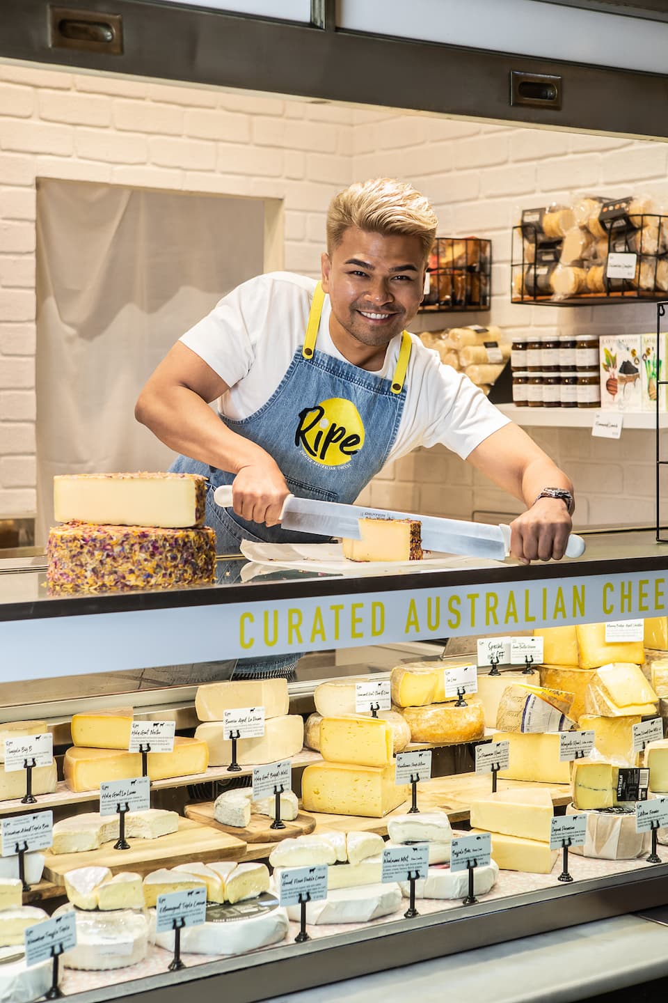 Hakim Halim slicing cheese on the counter