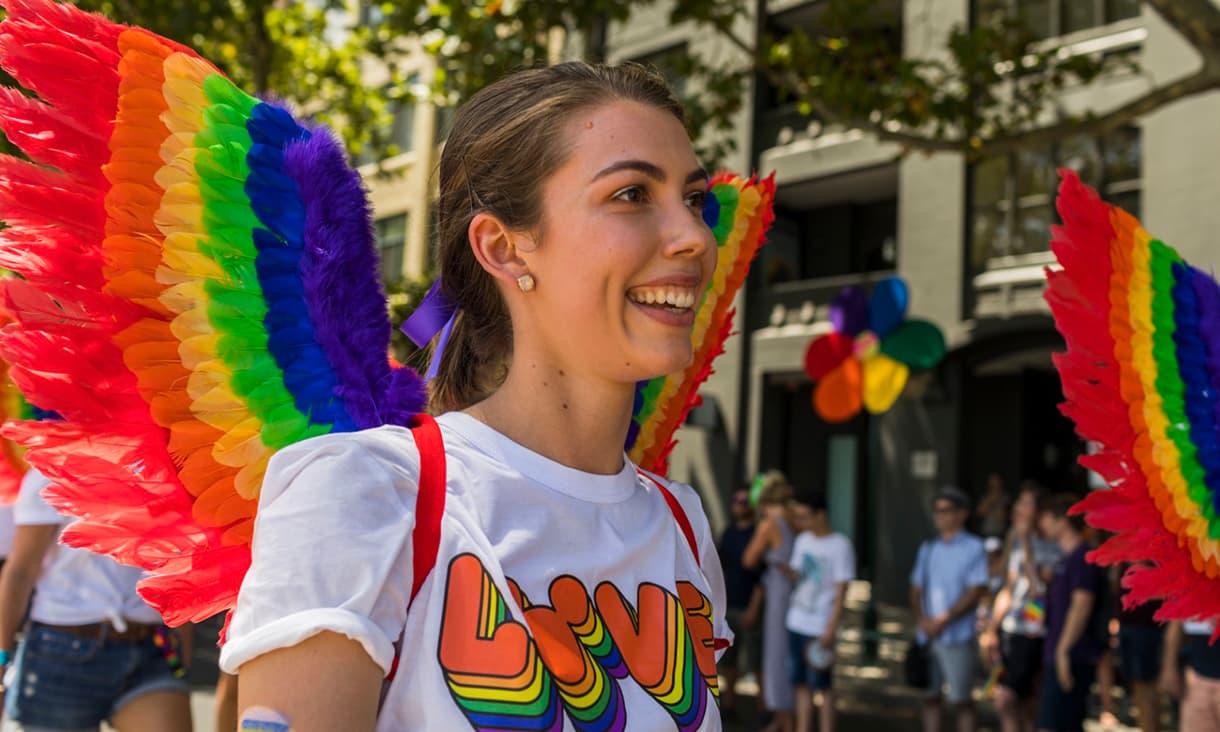 Lauren Phillips wearing rainbow wings and a 'LOVE' t-shirt at a Disney pride event.