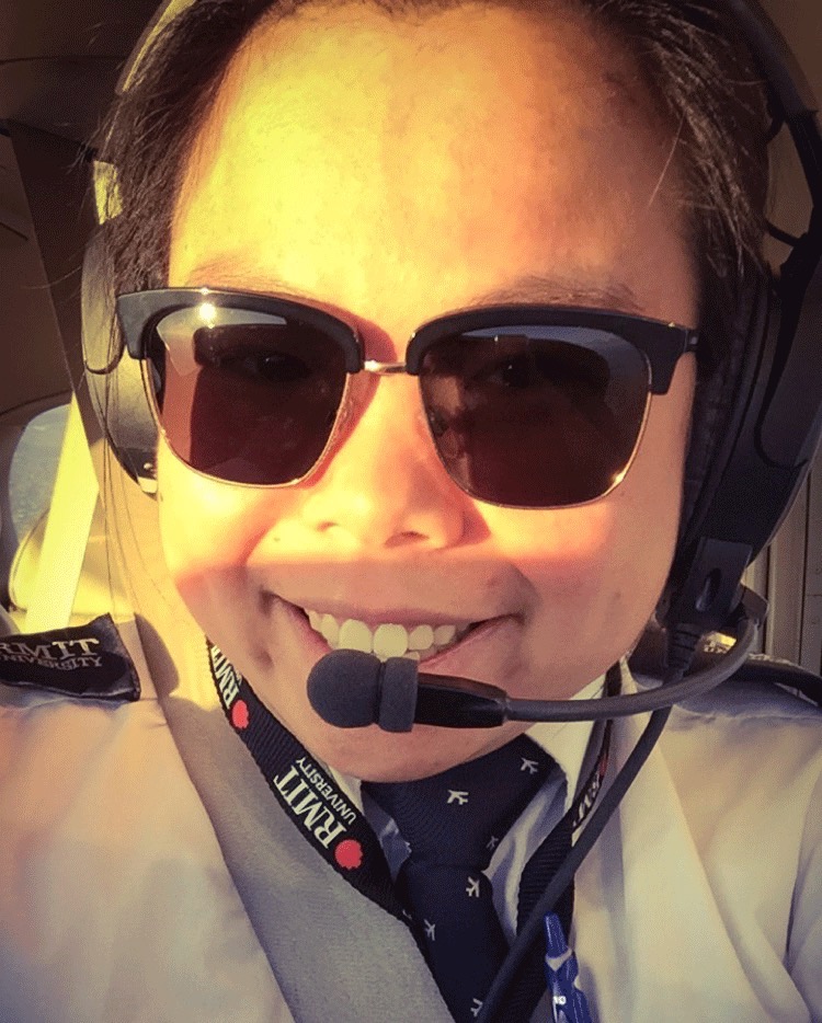 Female student pilot wearing sunglasses and an RMIT lanyard 