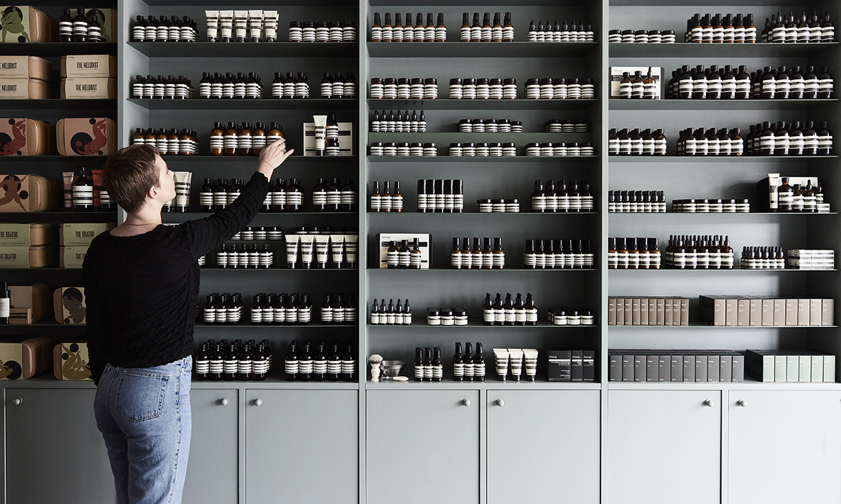 Beatrice Zly grabbing a product from the Aesop store display.