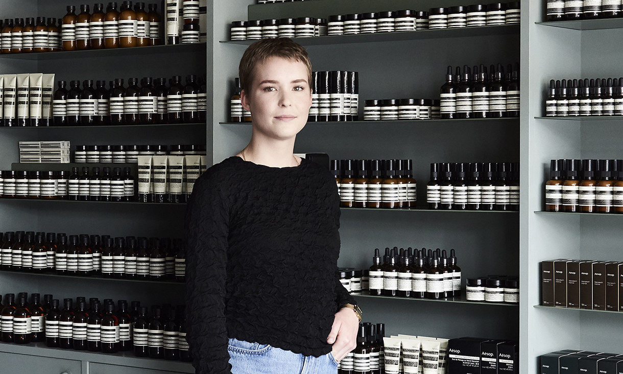 Beatrice Zly standing in front of an Aesop product display.