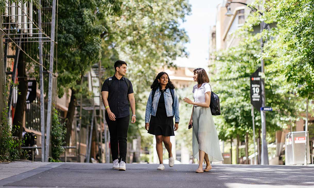 Three students walking on campus at Bowen street