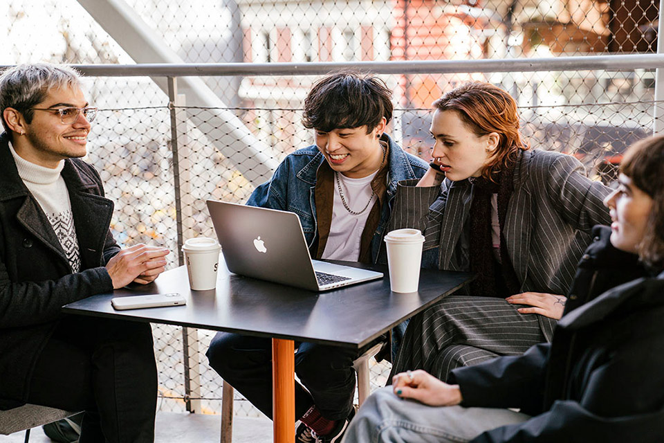 Students sitting around a laptop