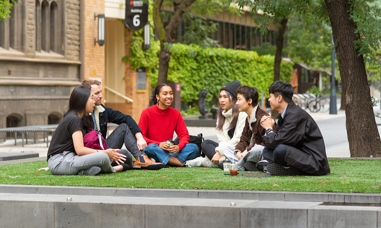 Students sitting on a lawn on campus