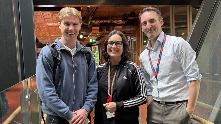 Lachlan smiles alongside Library staff